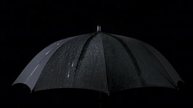 Yavaş çekim siyah şemsiye ve yağmur damlaları