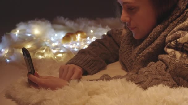 Video di una giovane donna che parla con una videochiamata tra le luci di Natale — Video Stock