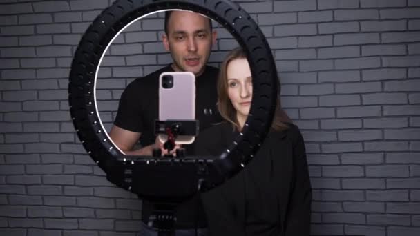 Tir de couple blogueur avec lampe annulaire sur fond de mur de briques — Video