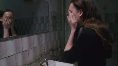 Yüzünü yıkayan genç bir kadının ağır çekim çekimi.