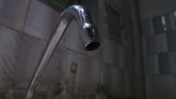 Zeitlupenaufnahmen von tropfendem Wasser aus dem Wasserhahn im armen Badezimmer — Stockvideo