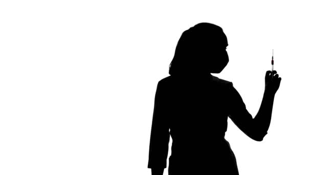 Видеозапись женского силуэта со шприцем — стоковое видео