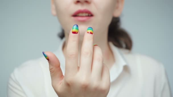 Woman with rainbow manicure beckoning finger — Stock Video