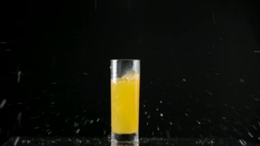 Portakal suyuna düşen buz küplerinin yavaş çekim videosu
