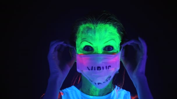Видео раздевания женщины в маске с испуганным раскрашенным лицом — стоковое видео