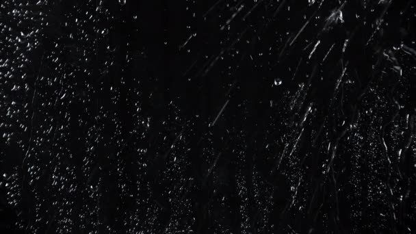 Slow motion 4k video of drops on black glass background — Stock Video