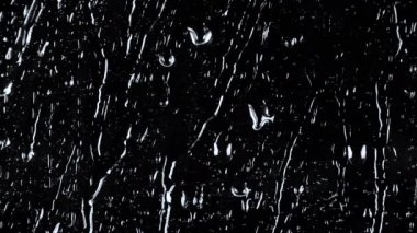 Siyah cam zemin üzerinde su damlalarının yavaş çekim görüntüleri