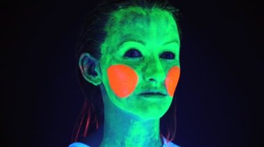 Ultraviyole ışıkla boyanmış korkunç yüzü olan kadının görüntüsü.