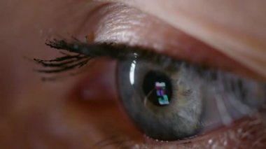 Akıllı telefonların ekranına bakarken gri gözlü bir kadının çekimleri.