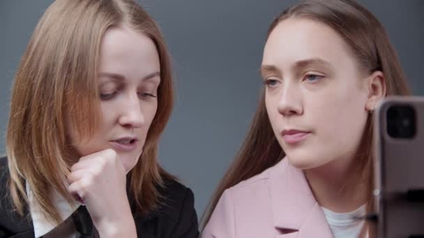 Deux blogueuses parlent avec des adeptes sur fond gris — Video