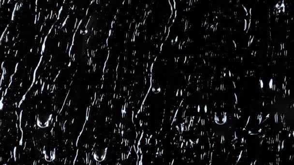 Slow motion beelden van water op zwart glas achtergrond — Stockvideo