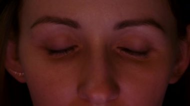 Karanlıkta dizüstü bilgisayarlara bakan genç bir kadının videosu.