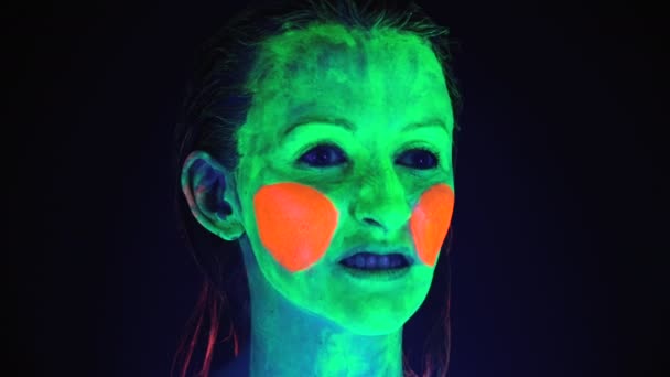 Erschießung einer Frau mit beängstigend aufgemaltem Gesicht im UV-Licht — Stockvideo