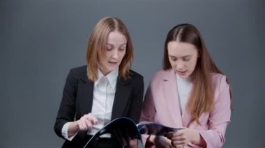 İş dünyası tarzında klasörlü tartışan iki kadının çekimleri