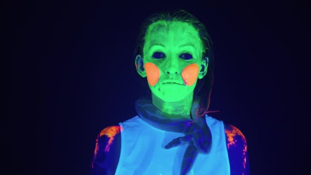 Vídeo de mulher com rosto assustador pintado e cobra no pescoço em luz ultravioleta — Vídeo de Stock