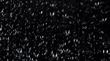 Siyah arkaplanda su damlalarının yavaş çekim görüntüleri