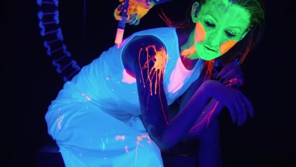 Video einer Frau mit flüssiger Farbe auf ihrem Körper im UV-Licht — Stockvideo
