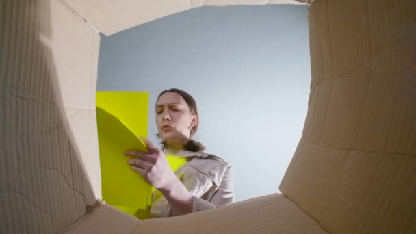 Mulher jogando papel amarelo amassado, vista inferior — Vídeo de Stock