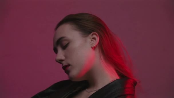 Tiro de mulher sentada no quarto com luz vermelha e azul — Vídeo de Stock