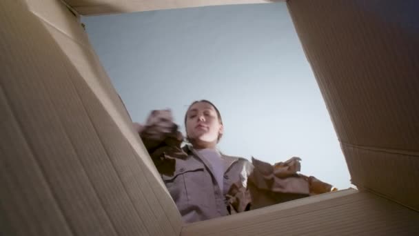 Nagranie kobiety rzucającej pogniecionym papierem, widok z dołu — Wideo stockowe