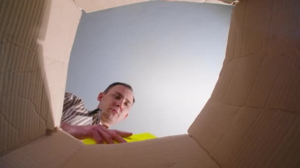Erschießung eines Mannes, der zerknittertes gelbes Papier wirft, Ansicht von unten — Stockvideo