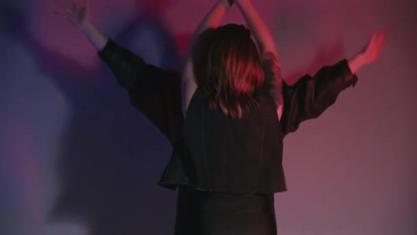 Schieten van dansende vrouwen in rood en blauw licht — Stockvideo