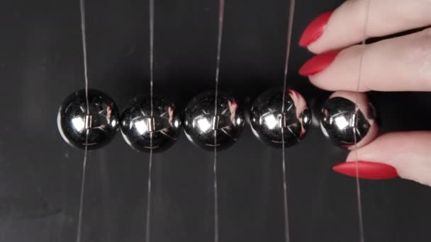 Vídeo de mulheres mão começou bolas de newtons de aço, vista superior — Vídeo de Stock