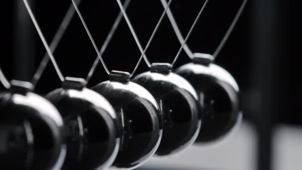 Verfilmung von grauen Newton-Kugeln in Bewegung auf schwarzem Hintergrund — Stockvideo