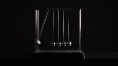 Siyah arkaplanda hareket halinde asılı Newton toplarının çekimleri