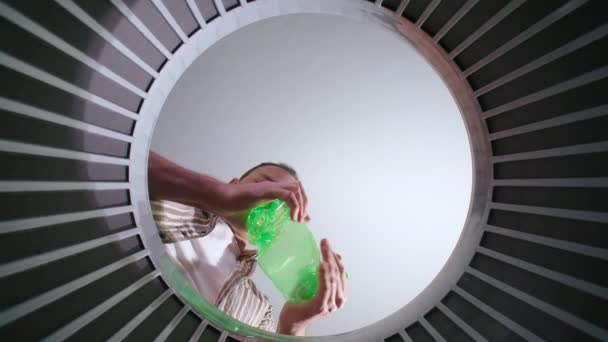 Brünetter Mann wirft Plastikflaschen, Ansicht von unten — Stockvideo
