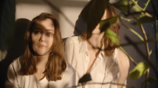 Filmato di due donne blogger che fanno selfie attraverso foglie di fiore — Video Stock
