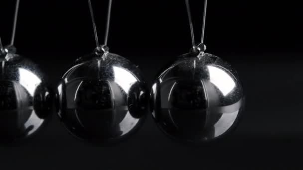 Tiro de bolas de cromo colgado newton en movimiento sobre fondo negro — Vídeos de Stock