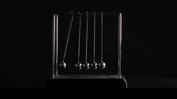 Images de boules de newton pendues en mouvement sur fond noir — Video