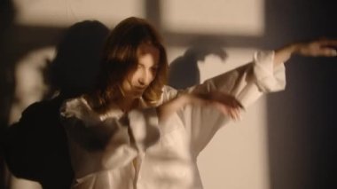 Gün batımında dans eden kadın pencerenin önünde