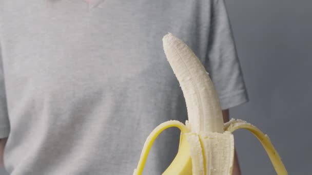Video av en kvinne som biter banan – stockvideo