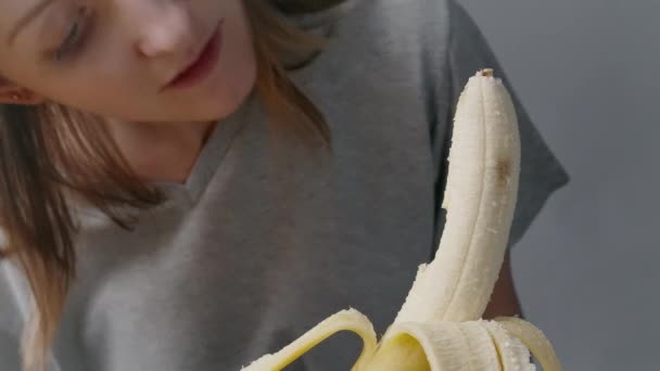 Beelden van een vrouw bijtende banaan — Stockvideo