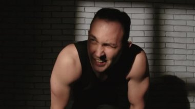Gölgelerde kum torbası olan yorgun bir adamın videosu.