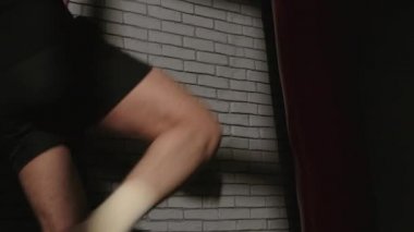 Kırmızı kum torbasıyla boksör vuruyor.