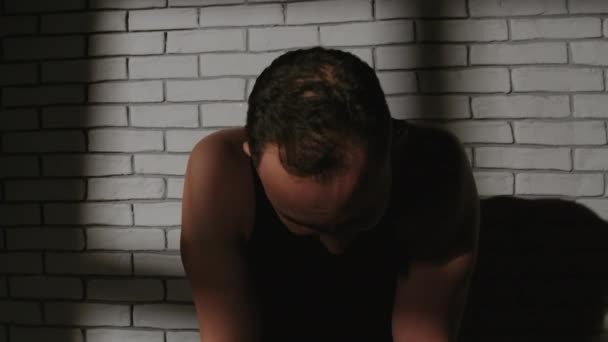 Filmato di uomo stanco con sacco da boxe nell'ombra — Video Stock