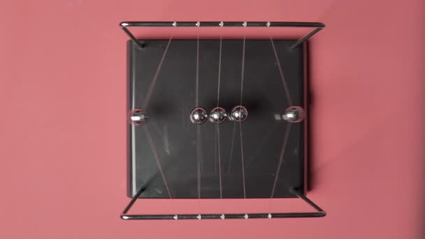 Video von Newtonbällen auf rosa Hintergrund, Ansicht von oben — Stockvideo