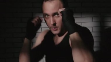 Gölgelerde bandajlı boksör vuruyor.