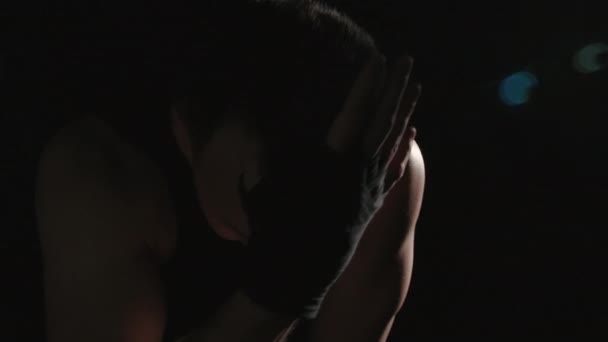 Втомлений чоловік з чорними бинтами в тіні — стокове відео