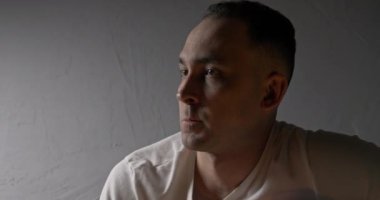 Gri arka planda düşünceli bir adamın çekimleri.