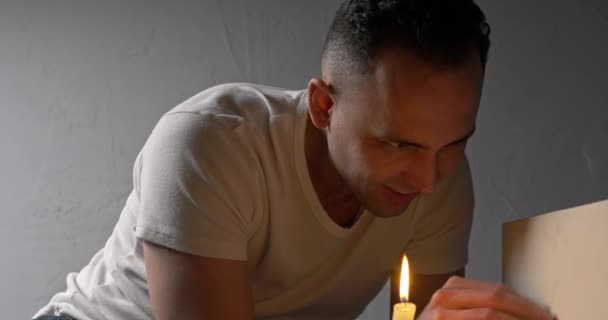 Fotografowanie człowieka czyszczenia pudełka w pobliżu świecy — Wideo stockowe