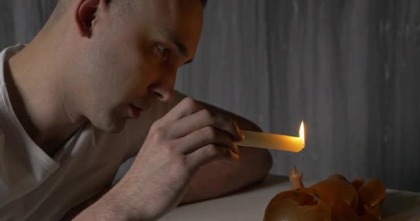 Man with candle and broken doll — Stock Video