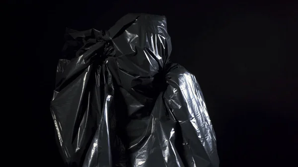 Mensch in schwarzer Mülltüte auf schwarz — Stockfoto
