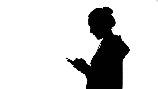 Silhueta meninas com smartphone no fundo branco — Fotografia de Stock