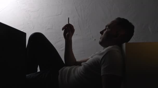 Záběry ležícího závislého na kouření s cigaretou ve stínu — Stock video