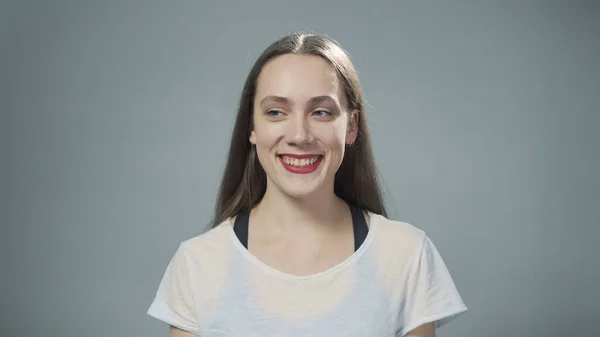 Photo of young smiling woman on grey — Stock Photo, Image