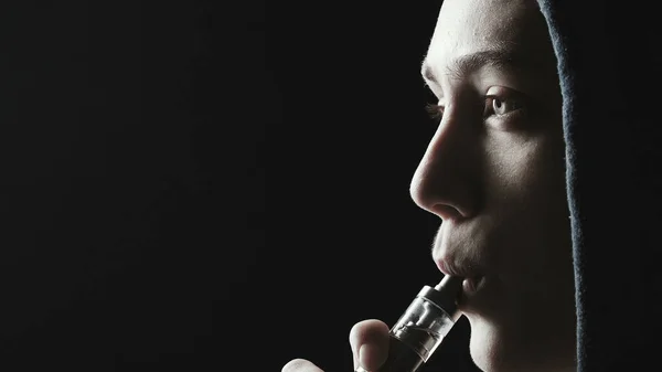 Фото дівчини-курця з електронною сигаретою в капюшоні — стокове фото
